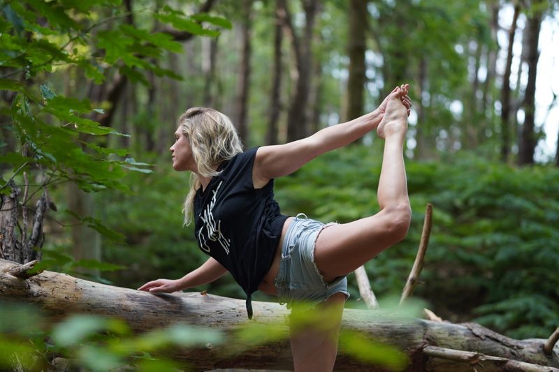 Hanne in een yogahouding buiten in de natuur